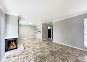 Thumbnail 5 of 19 - A room with a fireplace and tile flooring.