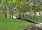 Thumbnail 19 of 19 - A black metal fence borders a grassy area with trees.