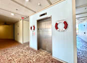 Thumbnail 23 of 25 - A hallway with a sign that says "EXIT" and a life preserver on the wall.