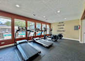 Thumbnail 9 of 17 - A gym with treadmills and a wall with the words "Believe Discipline Strong Consistency Secret" written on it.