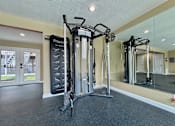Thumbnail 10 of 17 - A gym with a mirror, treadmill, and weights.