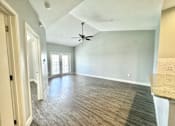 Thumbnail 6 of 25 - A room with a ceiling fan and wood flooring.