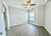 Thumbnail 5 of 25 - A room with a ceiling fan and a door.