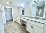 Thumbnail 12 of 25 - A bathroom with a sink, mirror, and toilet.