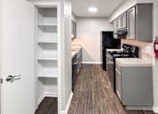 Thumbnail 1 of 17 - A kitchen with a black fridge and stove, and a white door.