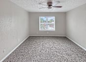 Thumbnail 6 of 17 - A room with a ceiling fan and a window with blinds.