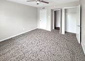 Thumbnail 3 of 17 - A room with a ceiling fan and carpeted floor.
