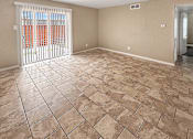 Thumbnail 7 of 17 - A room with tiled flooring and a sliding glass door.
