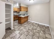 Thumbnail 8 of 17 - A kitchen with a tile floor and wooden cabinets.