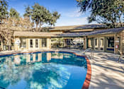 Thumbnail 13 of 13 - Relaxing swimming pool area at Greenbriar Place 55+ Apartments in Corpus Christi, featuring lounge chairs and landscaped surroundings.