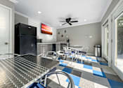Thumbnail 4 of 5 - A kitchen with a black fridge and a dining table with chairs.