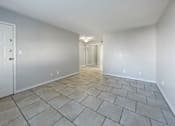 Thumbnail 15 of 15 - A room with a tiled floor and a white door.