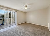 Thumbnail 12 of 15 - A room with a ceiling fan and a sliding glass door.