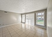 Thumbnail 4 of 24 - Tile floor living room with sliding patio door – Borders Apartments Brownsville TX