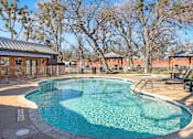 Thumbnail 16 of 28 - Swimming pool with lounge chairs and landscaping at Verano Oaks Apartments