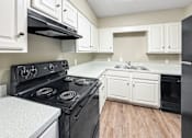 Thumbnail 28 of 28 - Kitchen with white cabinets and black appliances at Verano Oaks Apartments