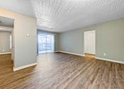 Thumbnail 19 of 28 - Spacious living room with neutral walls and wood-style flooring at Verano Oaks Apartments in Hurst, TX