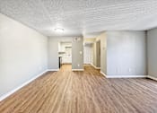 Thumbnail 20 of 28 - Spacious living room with neutral walls and wood-style flooring at Verano Oaks Apartments in Hurst, TX