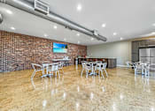 Thumbnail 23 of 28 - Clubhouse interior with seating area and bright lighting