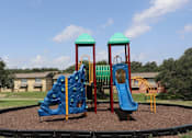 Thumbnail 17 of 19 - Playground with blue slide at Sierra Ranch Apartments in San Antonio, TX.