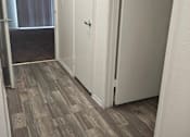 Thumbnail 14 of 36 - A bedroom with a bed, pillows, and a wooden floor at Raintree Apartments, CA 92346