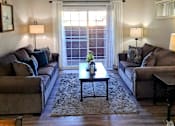 Thumbnail 4 of 36 - A living room with two couches, a coffee table, and a window at Raintree Apartments, CA 92346