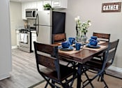 Thumbnail 6 of 36 - A dining room with a table set for two and a sign that says at Raintree Apartments, CA 92346
