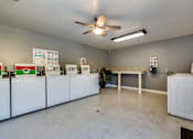 Thumbnail 19 of 23 - a laundry room with machines and a ceiling fan