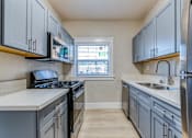 Thumbnail 13 of 20 - a kitchen with gray cabinets and white countertops