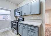 Thumbnail 11 of 20 - a kitchen with gray cabinets and stainless steel appliances