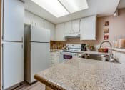 Thumbnail 26 of 29 - a kitchen with white cabinets and a granite counter top