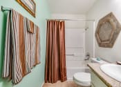 Thumbnail 14 of 29 - a bathroom with a white sink and toilet next to a shower with a curtain