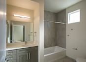 Thumbnail 19 of 19 - A bathroom with a white sink and a white bathtub.