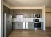 Thumbnail 15 of 19 - Apartment kitchen with refrigerator, microwave and stove