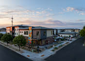 Thumbnail 3 of 24 - A street view of a modern building with a colorful mural on the side.