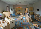 Thumbnail 24 of 24 - A colorful playroom with a slide and a play kitchen.