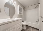 Thumbnail 31 of 36 - A white bathroom with a toilet, sink, and shower.
