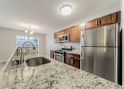 Thumbnail 3 of 36 - Townhome updated kitchen with granite counters and stainless steel appliances.