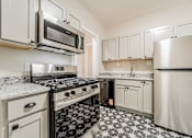 Thumbnail 25 of 39 - Updated kitchen with stainless steel appliances and a black and white floor. at Integrity Gold Coast Apartments, Apartments, Cleveland, OH