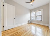 Thumbnail 39 of 39 - A room with a white door, a window with blinds, and a ceiling fan.