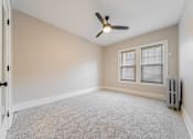 Thumbnail 28 of 39 - Carpeted bedroom with modern ceiling fan.