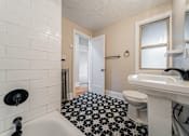 Thumbnail 27 of 39 - A white sink with a black faucet in a bathroom.