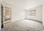 Thumbnail 17 of 23 - A room with a carpeted floor and a window with bars.