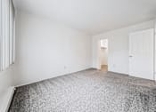 Thumbnail 7 of 23 - A room with a grey carpet and white walls.
