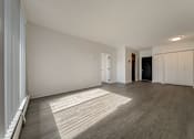 Thumbnail 24 of 29 - A room with wooden flooring and white walls.