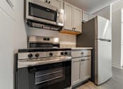Thumbnail 29 of 29 - A modern kitchen with a stove, oven, microwave, and refrigerator.