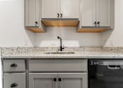 Thumbnail 28 of 29 - A modern kitchen with a granite countertop and stainless steel appliances.