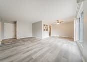 Thumbnail 22 of 32 - A room with wooden flooring and a ceiling fan.