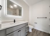 Thumbnail 2 of 18 - A bathroom with a white toilet and a sink with a mirror above it at Westwood Meadows, Westlake, OH, 44145