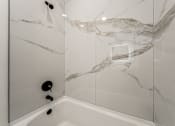 Thumbnail 3 of 18 - A white bathroom with a marble patterned shower at Westwood Meadows, Westlake, OH, 44145